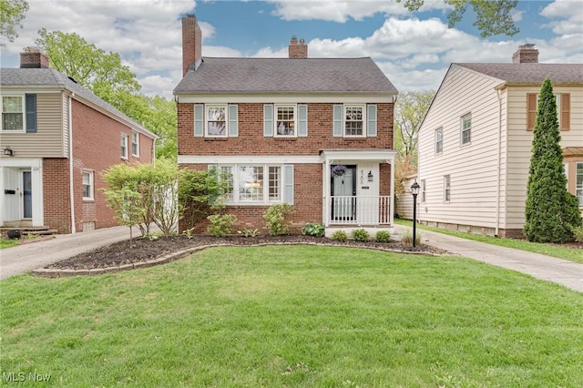 4206 Bushnell Rd, University Heights, OH 44118 - view of front of house with brick siding, a front lawn, and a chimney