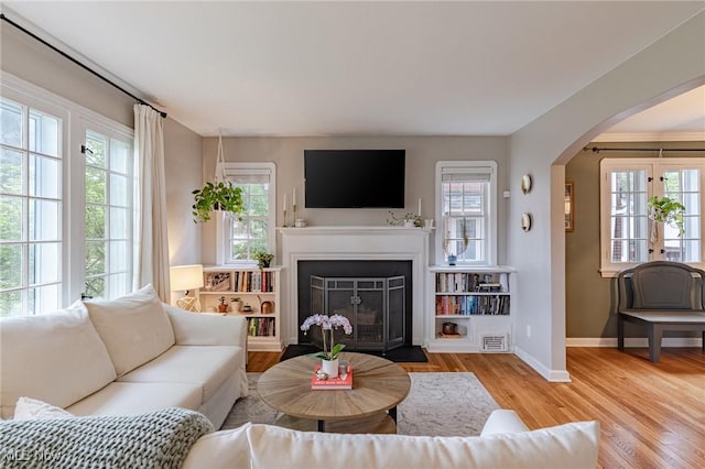 4206 Bushnell Rd, University Heights, OH 44118 - living area featuring healthy amount of natural light, baseboards, arched walkways, and wood finished floors