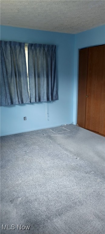 564 Stephens Rd, Akron, OH 44312 - unfurnished bedroom featuring carpet flooring, a textured ceiling, and a closet