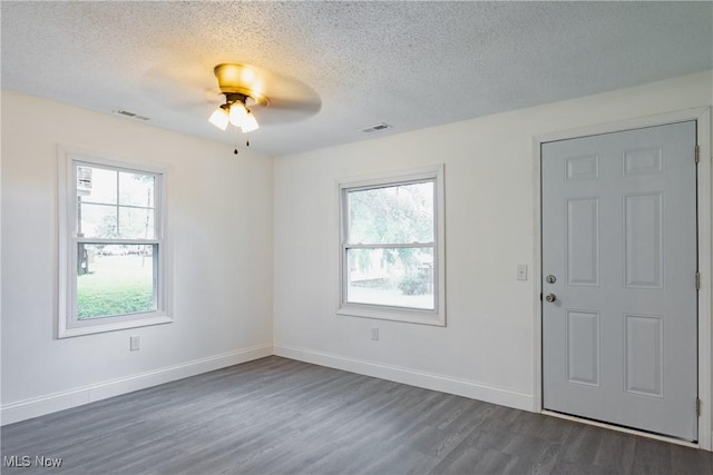 2403 45th St, Parkersburg, WV 26104 - spare room featuring a textured ceiling, dark wood-type flooring, healthy amount of natural light, ceiling fan, and baseboards