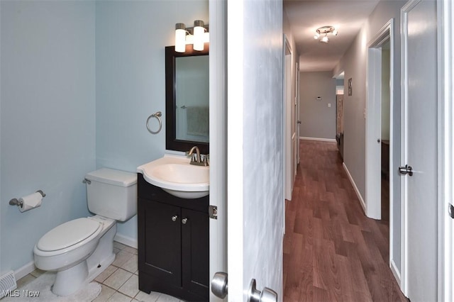 2932 Pease Dr Unit 210, Rocky River, OH 44116 - half bathroom featuring toilet, vanity, wood finished floors, and baseboards