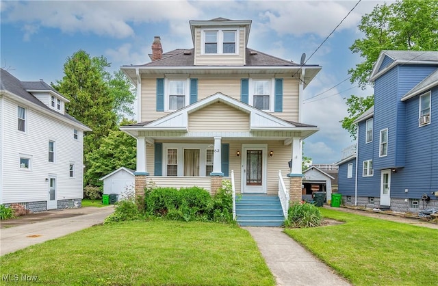 52 20th St SW, Barberton, OH 44203 - american foursquare style home with a porch, a front lawn, and a chimney
