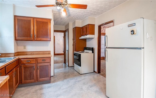 52 20th St SW, Barberton, OH 44203 - kitchen featuring freestanding refrigerator, range with electric stovetop, under cabinet range hood, brown cabinetry, and a textured ceiling