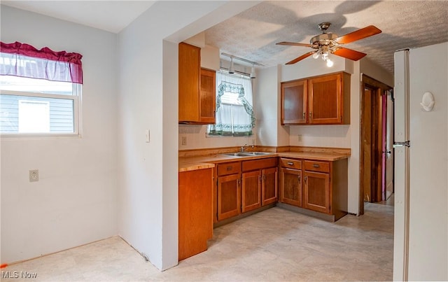 52 20th St SW, Barberton, OH 44203 - kitchen featuring brown cabinets, light floors, ceiling fan, light countertops, and a sink