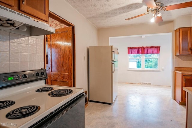 52 20th St SW, Barberton, OH 44203 - kitchen featuring electric range oven, freestanding refrigerator, under cabinet range hood, a ceiling fan, and brown cabinets