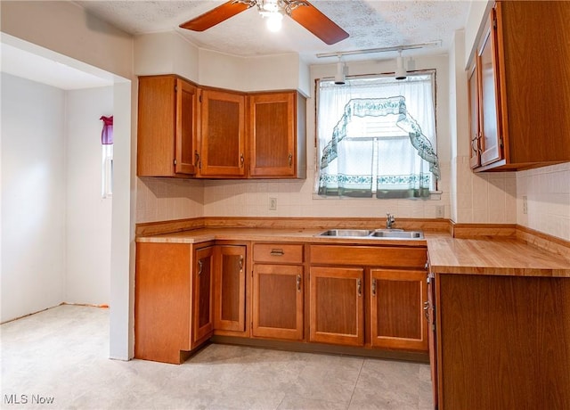 52 20th St SW, Barberton, OH 44203 - kitchen with a sink, brown cabinetry, a ceiling fan, and a textured ceiling