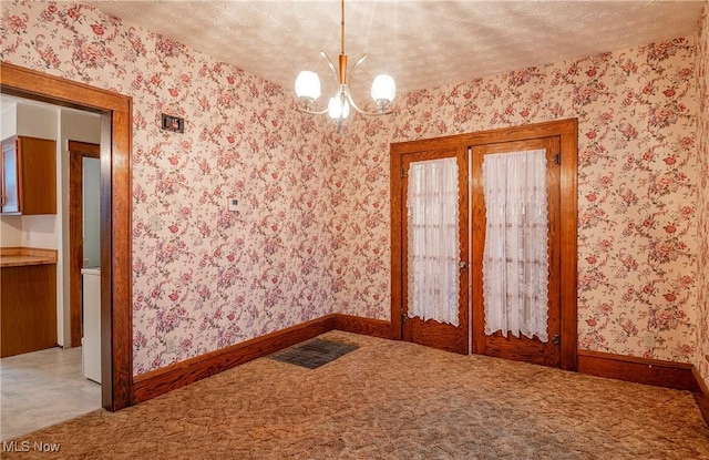 52 20th St SW, Barberton, OH 44203 - carpeted spare room with a chandelier, wallpapered walls, baseboards, and a textured ceiling