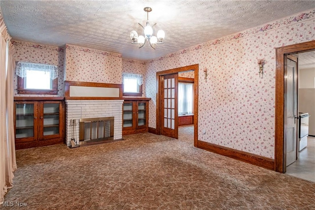 52 20th St SW, Barberton, OH 44203 - unfurnished living room featuring wallpapered walls, a textured ceiling, a chandelier, plenty of natural light, and carpet floors