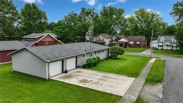 123 Wabash Ave, Orrville, OH 44667 - view of front of property featuring driveway, roof with shingles, a front lawn, an attached garage, and a residential view
