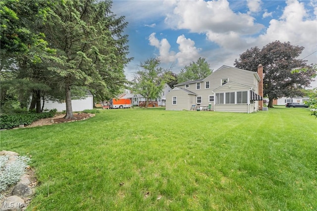 20110 Carolyn Ave, Rocky River, OH 44116 - back of house with a chimney, a lawn, and a sunroom