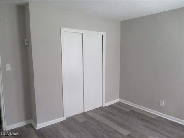 6453 Poplar Dr, Independence, OH 44131 - unfurnished bedroom featuring wood finished floors, a closet, and baseboards