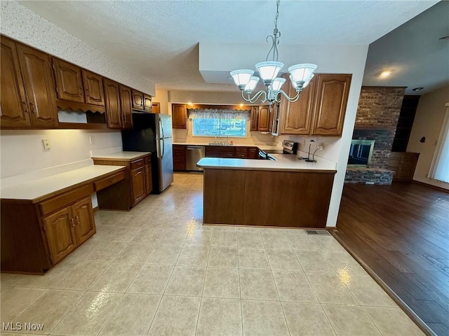 305 Flintwood Dr, Marietta, OH 45750 - kitchen with stainless steel appliances, a sink, a chandelier, light countertops, and a peninsula