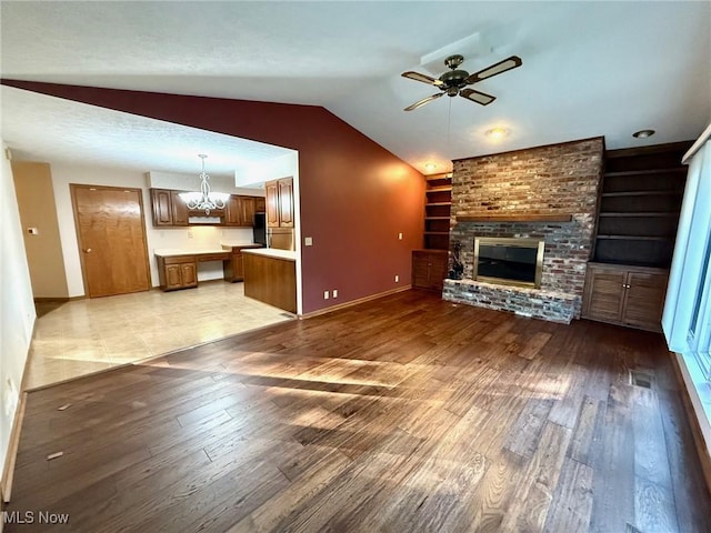 305 Flintwood Dr, Marietta, OH 45750 - unfurnished living room featuring built in shelves, light wood-style floors, lofted ceiling, ceiling fan, and a fireplace
