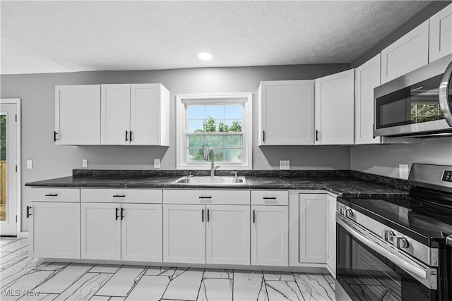 23595 Sandy Creek Rd, Minerva, OH 44657 - kitchen with appliances with stainless steel finishes, a sink, light marble finish flooring, white cabinetry, and recessed lighting