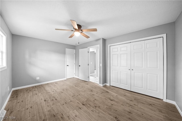 23595 Sandy Creek Rd, Minerva, OH 44657 - unfurnished bedroom with wood finished floors, baseboards, a ceiling fan, and a closet