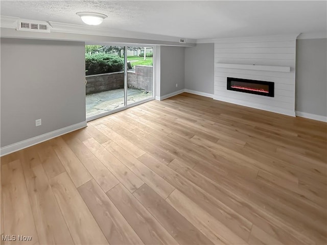 9530 Cove Dr Unit C-26, North Royalton, OH 44133 - unfurnished living room featuring a large fireplace, wood finished floors, baseboards, and a textured ceiling