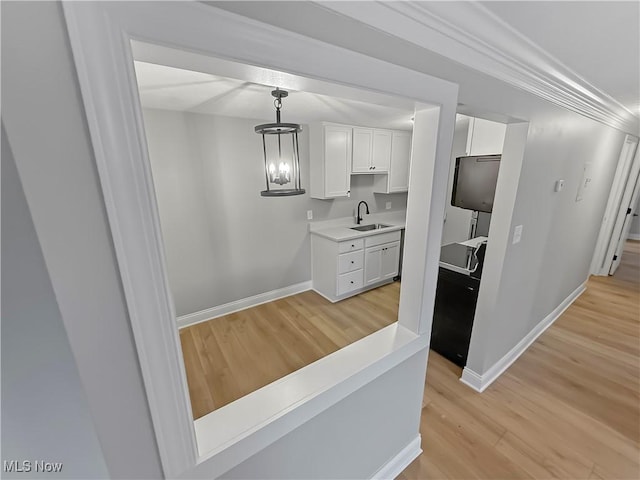 9530 Cove Dr Unit C-26, North Royalton, OH 44133 - kitchen featuring light wood finished floors, white cabinetry, baseboards, light countertops, and a sink