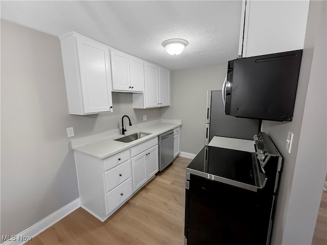 9530 Cove Dr Unit C-26, North Royalton, OH 44133 - kitchen with dishwasher, a sink, black / electric stove, light wood finished floors, and white cabinets