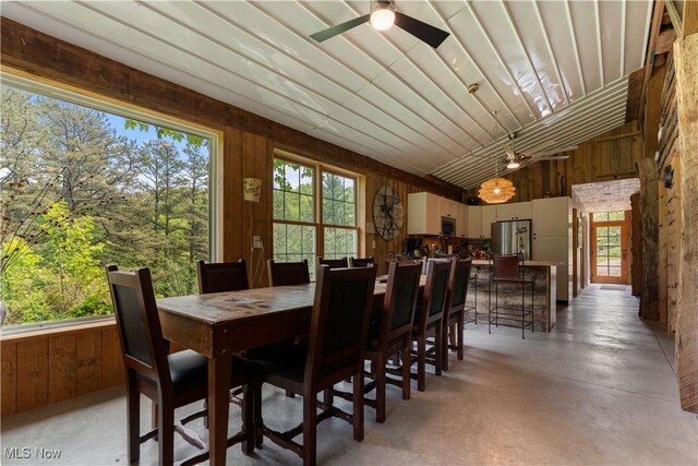 15216 Grove Rd SE, Port Washington, OH 43837 - dining room featuring ceiling fan, wood walls, finished concrete floors, and high vaulted ceiling