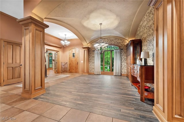 3109 Kennesaw Cir NW, Canton, OH 44708 - foyer entrance with a chandelier, ornate columns, vaulted ceiling, arched walkways, and hardwood / wood-style flooring