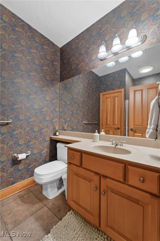 3109 Kennesaw Cir NW, Canton, OH 44708 - half bathroom with vanity, tile patterned floors, toilet, wallpapered walls, and baseboards