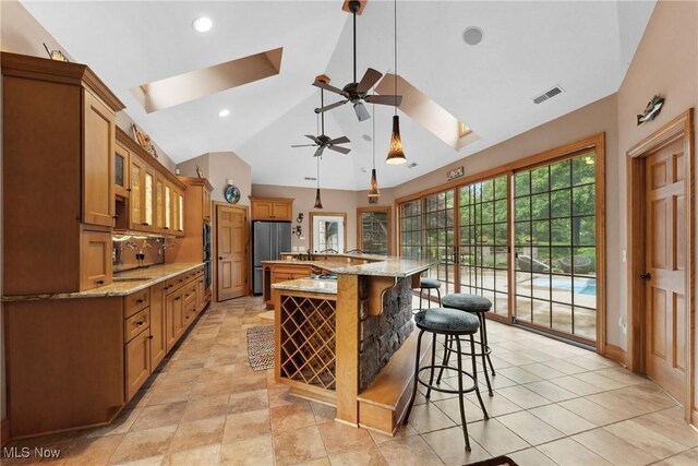 3109 Kennesaw Cir NW, Canton, OH 44708 - kitchen with a skylight, ceiling fan, stainless steel appliances, vaulted ceiling, and a kitchen breakfast bar