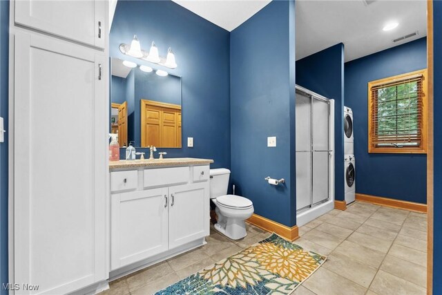 3109 Kennesaw Cir NW, Canton, OH 44708 - bathroom with stacked washing machine and dryer, vanity, toilet, a shower stall, and baseboards