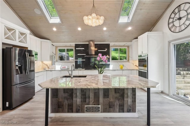 179 High St, Chagrin Falls, OH 44022 - kitchen featuring appliances with stainless steel finishes, a skylight, a sink, wood ceiling, and decorative backsplash