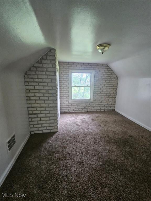 72 Idaho Rd, Austintown, OH 44515 - additional living space featuring brick wall, lofted ceiling, carpet floors, and a textured ceiling