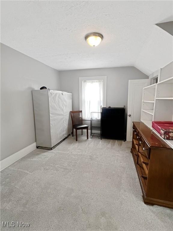 9007 Plymouth Ave, Garfield Heights, OH 44125 - living area featuring light carpet, a textured ceiling, lofted ceiling, and baseboards