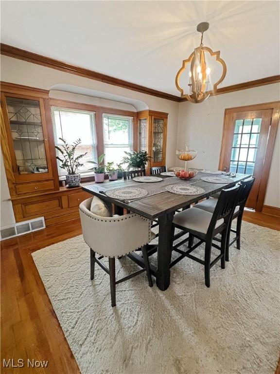 9007 Plymouth Ave, Garfield Heights, OH 44125 - dining space featuring a chandelier, light wood-style floors, and ornamental molding