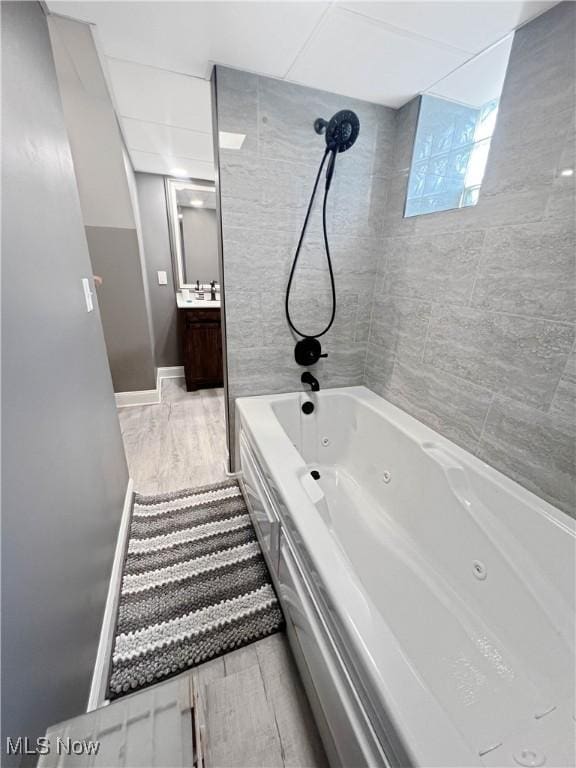 9007 Plymouth Ave, Garfield Heights, OH 44125 - full bathroom with vanity, a combined bath / shower with jetted tub, wood finished floors, and baseboards