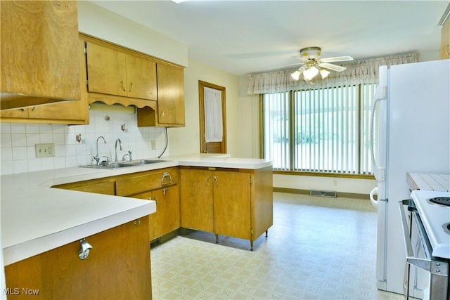 3763 E River Rd, Newton Falls, OH 44444 - kitchen with a sink, range with electric cooktop, a peninsula, a ceiling fan, and brown cabinets