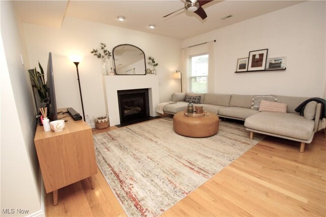 3253 Seven Bridges Rd, Medina, OH 44256 - living area with wood finished floors, a ceiling fan, and a fireplace with flush hearth