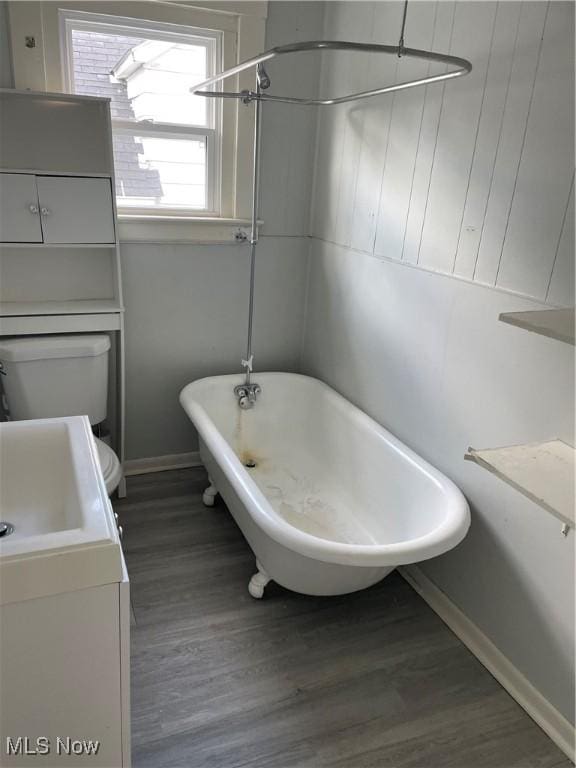 1717 Clark Ave, Cleveland, OH 44109 - bathroom featuring a freestanding bath, wood finished floors, vanity, baseboards, and toilet