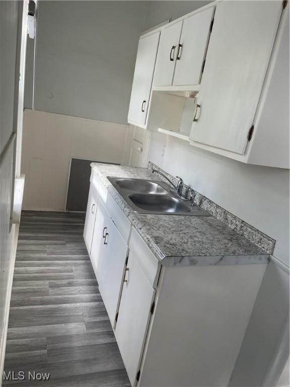 1717 Clark Ave, Cleveland, OH 44109 - kitchen featuring a sink, white cabinetry, and wood finished floors
