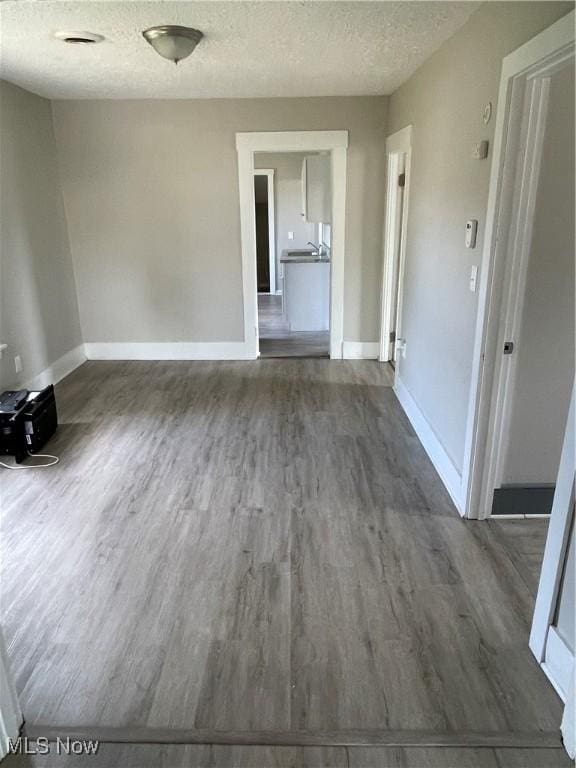 1717 Clark Ave, Cleveland, OH 44109 - unfurnished room with a textured ceiling, wood finished floors, and baseboards