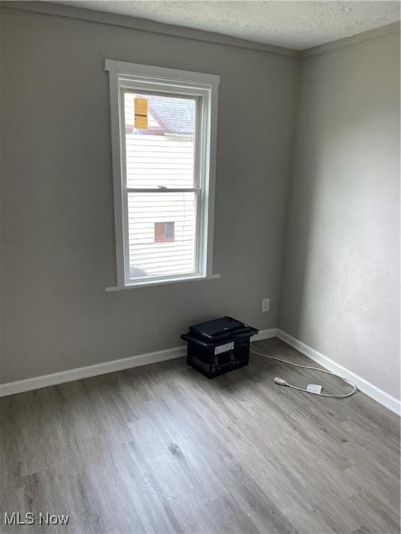 1717 Clark Ave, Cleveland, OH 44109 - empty room with wood finished floors, a textured ceiling, and baseboards