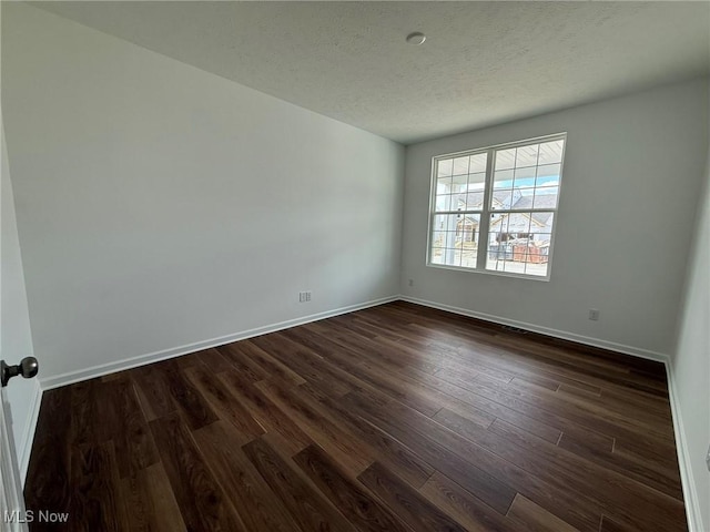 23669 Wallys Way, Columbia Station, OH 44028 - empty room featuring dark wood finished floors, baseboards, and a textured ceiling