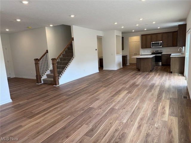 23669 Wallys Way, Columbia Station, OH 44028 - unfurnished living room featuring a sink, wood finished floors, stairs, recessed lighting, and baseboards