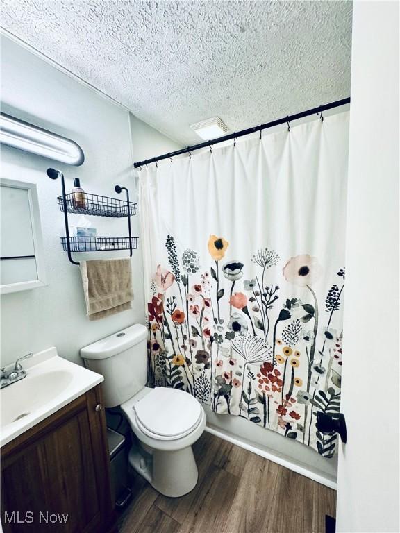 156 N Beverly, Austintown, OH 44515 - full bathroom with wood finished floors, vanity, a textured ceiling, toilet, and shower / bathtub combination with curtain