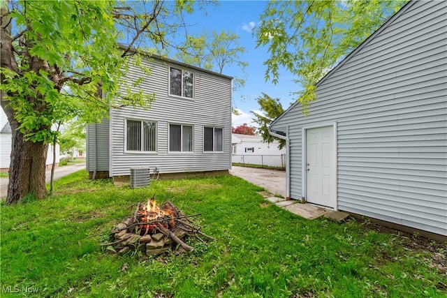 5688 Shawnee Dr, Lyndhurst, OH 44124 - rear view of property featuring a fire pit, a yard, and central AC