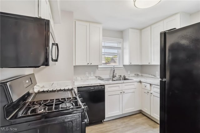 13641 Cedar Rd, University Heights, OH 44118 - kitchen featuring black appliances, a sink, light countertops, and white cabinetry