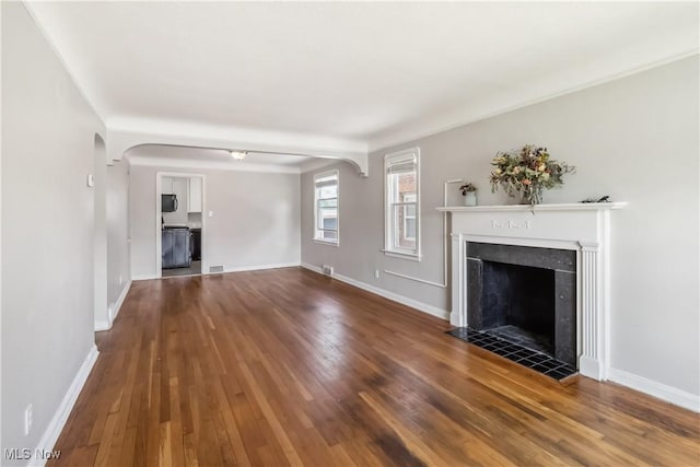 13641 Cedar Rd, University Heights, OH 44118 - unfurnished living room with a fireplace, wood-type flooring, arched walkways, and baseboards