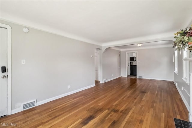 13641 Cedar Rd, University Heights, OH 44118 - unfurnished room with arched walkways, wood finished floors, baseboards, and a smoke detector
