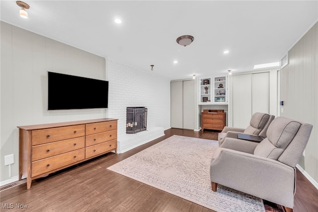 17404 Falling Water Rd, Strongsville, OH 44136 - living room with wood finished floors, a fireplace, a decorative wall, built in features, and recessed lighting
