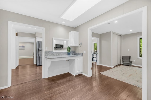 17404 Falling Water Rd, Strongsville, OH 44136 - kitchen with appliances with stainless steel finishes, white cabinets, dark wood-style flooring, a skylight, and baseboards