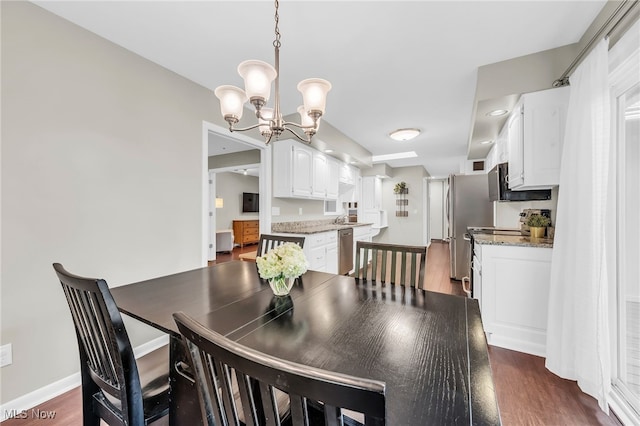 17404 Falling Water Rd, Strongsville, OH 44136 - dining area featuring a chandelier, dark wood finished floors, and baseboards
