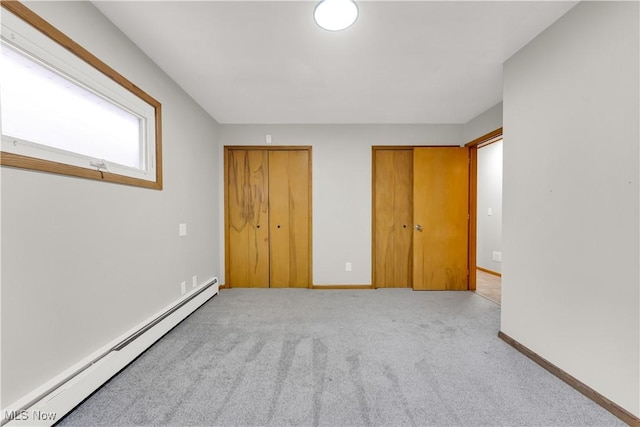 10701 Mountview Ave, Garfield Heights, OH 44125 - unfurnished bedroom featuring a baseboard heating unit, two closets, carpet, and baseboards
