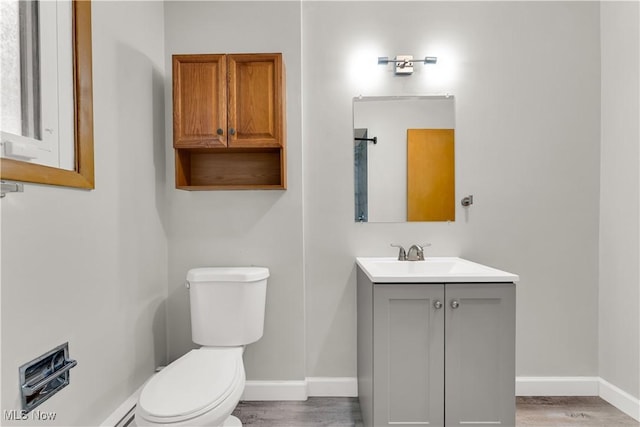 10701 Mountview Ave, Garfield Heights, OH 44125 - bathroom with toilet, wood finished floors, vanity, and baseboards